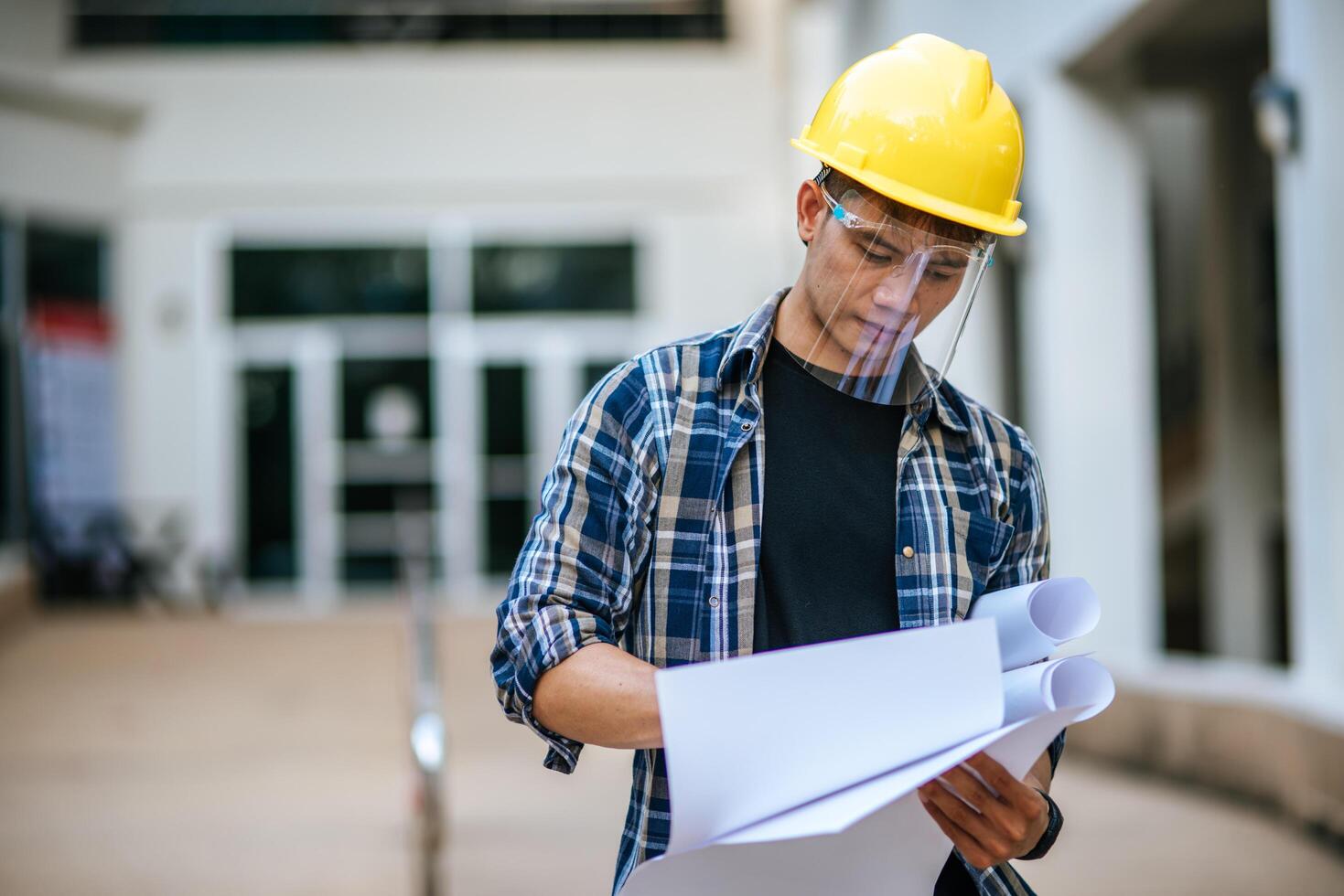 architecten houden het bouwplan vast en controleren het werk. foto