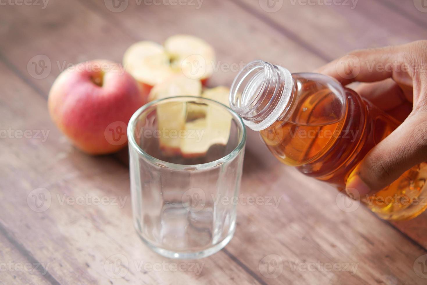 jonge man pruilende appelsap in een glas foto