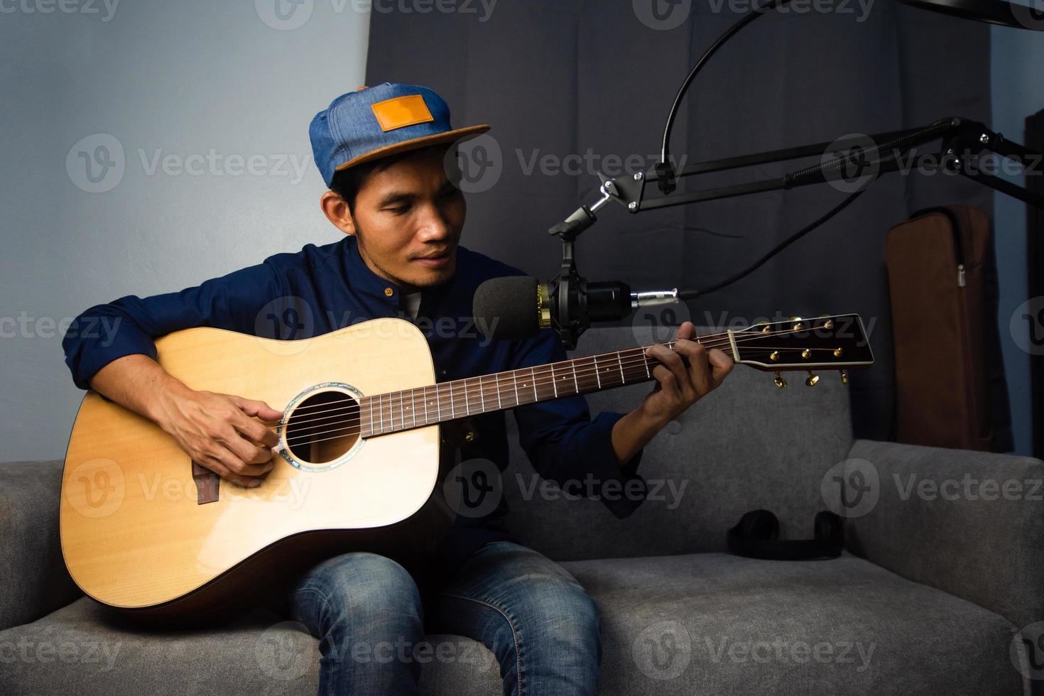 man die gitaar speelt in thuisstudio live online streamen foto