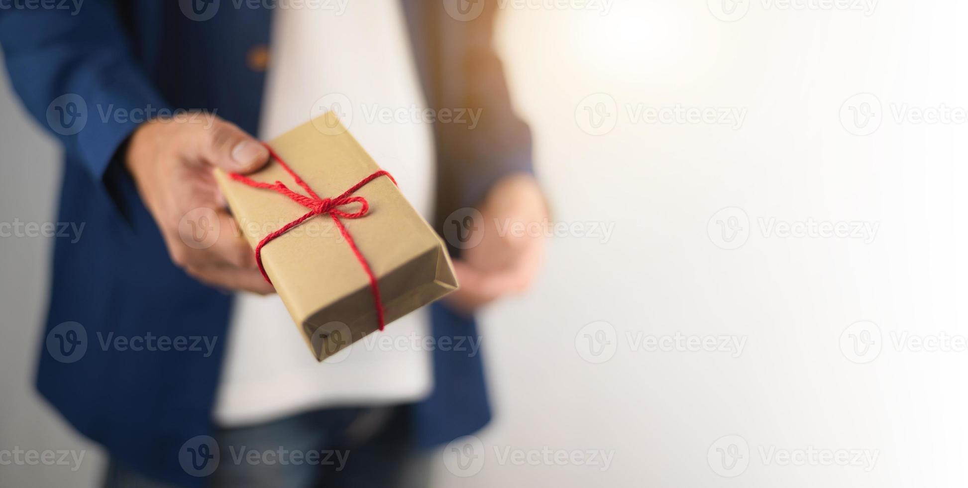 hand met geschenkdoos, nieuwjaarsgeschenkdoos, kerstcadeaudoos, kopieerruimte. Kerstmis, jaar, verjaardagsconcept. foto