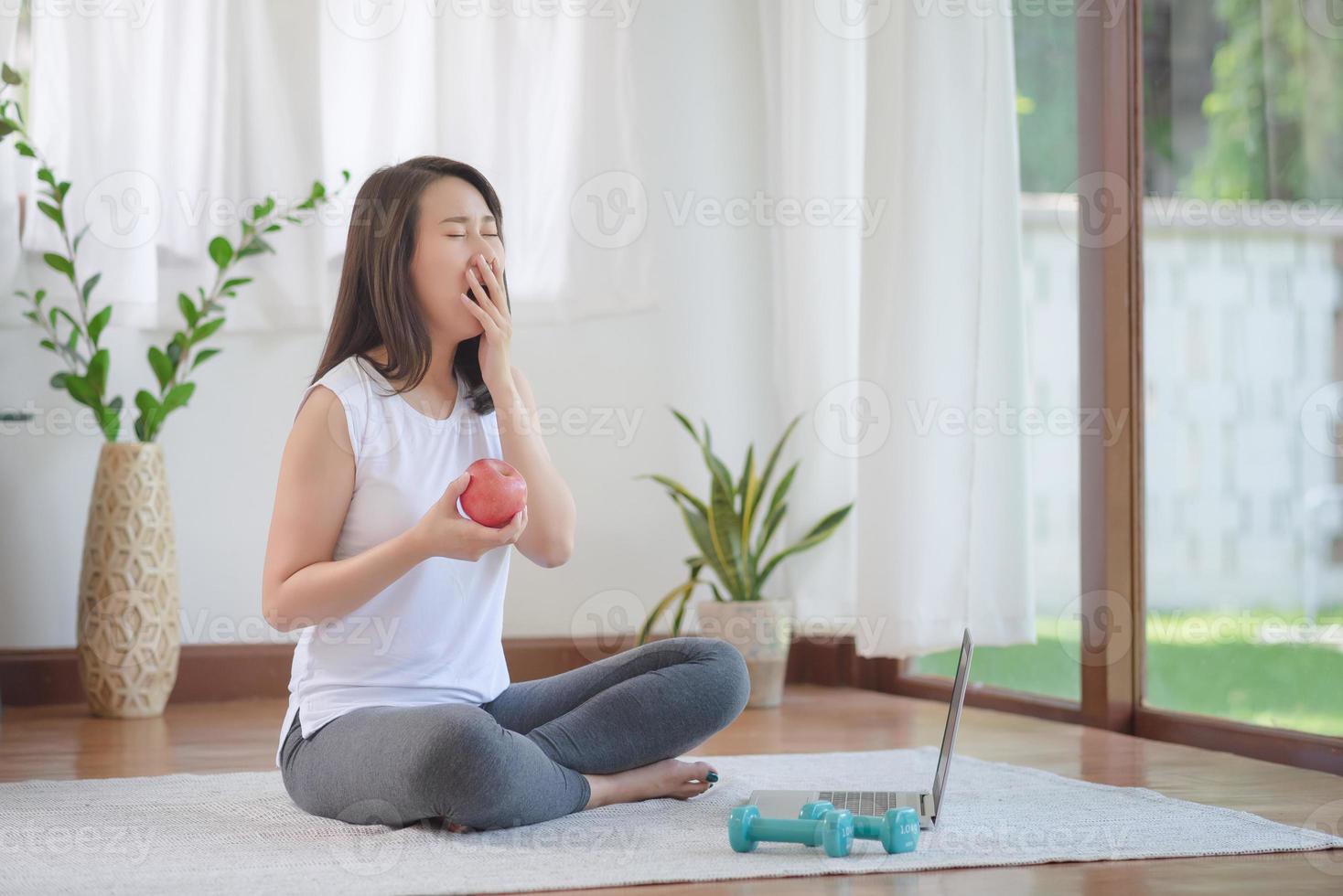 mooie aziatische vrouw die fit blijft door thuis te oefenen voor een gezonde trendlevensstijl foto