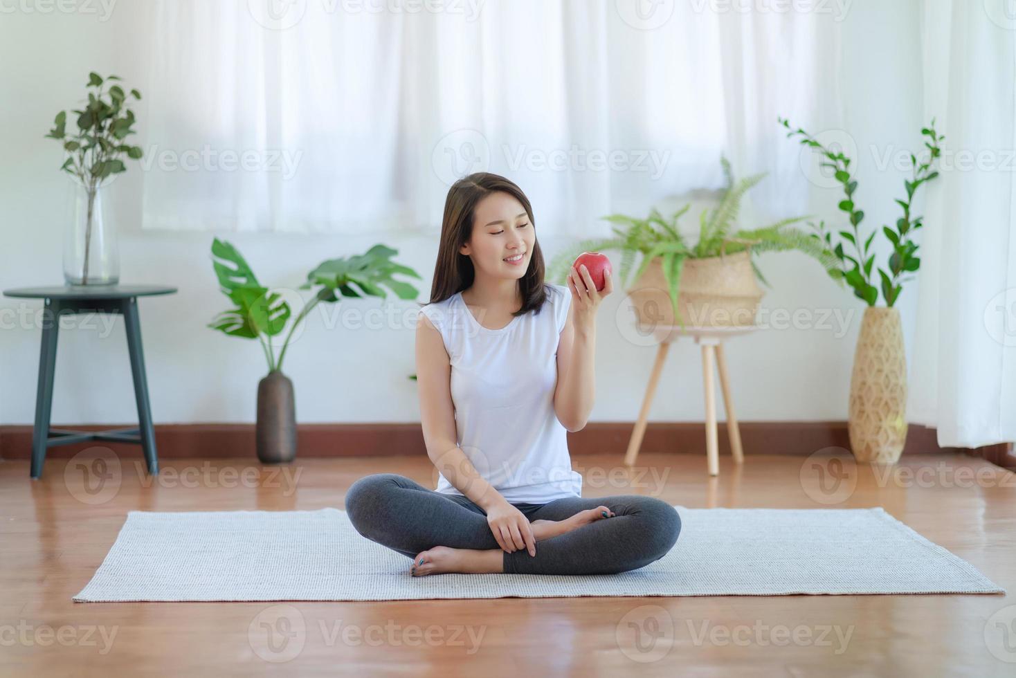 mooie aziatische vrouw die fit blijft door thuis te oefenen voor een gezonde trendlevensstijl foto