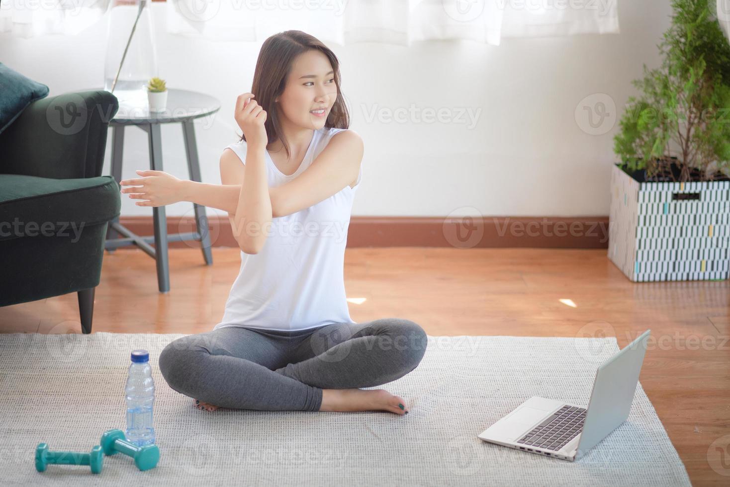 mooie aziatische vrouw die fit blijft door thuis te oefenen voor een gezonde trendlevensstijl foto