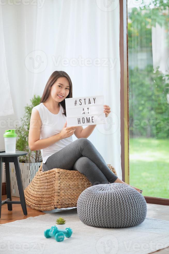 mooie aziatische vrouw die fit blijft door thuis te oefenen voor een gezonde trendlevensstijl foto