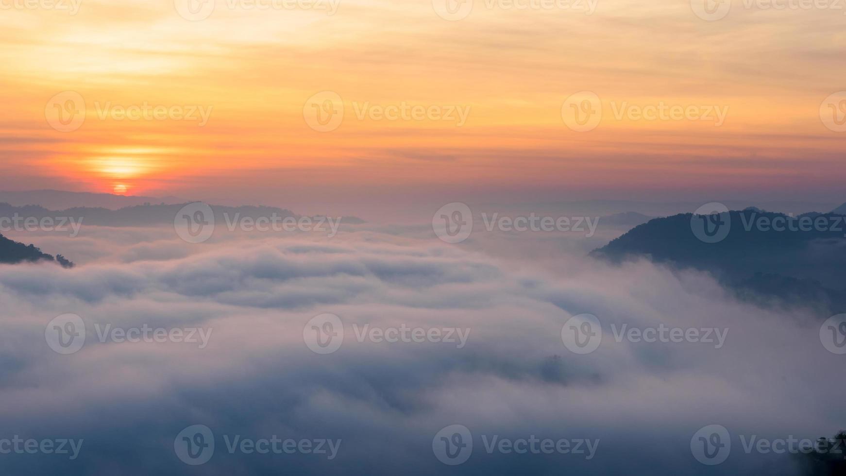 panoramisch uitzicht op verbazingwekkende mist die over de natuurbergen beweegt tijdens zonsopgang in het bergengebied in thailand. foto