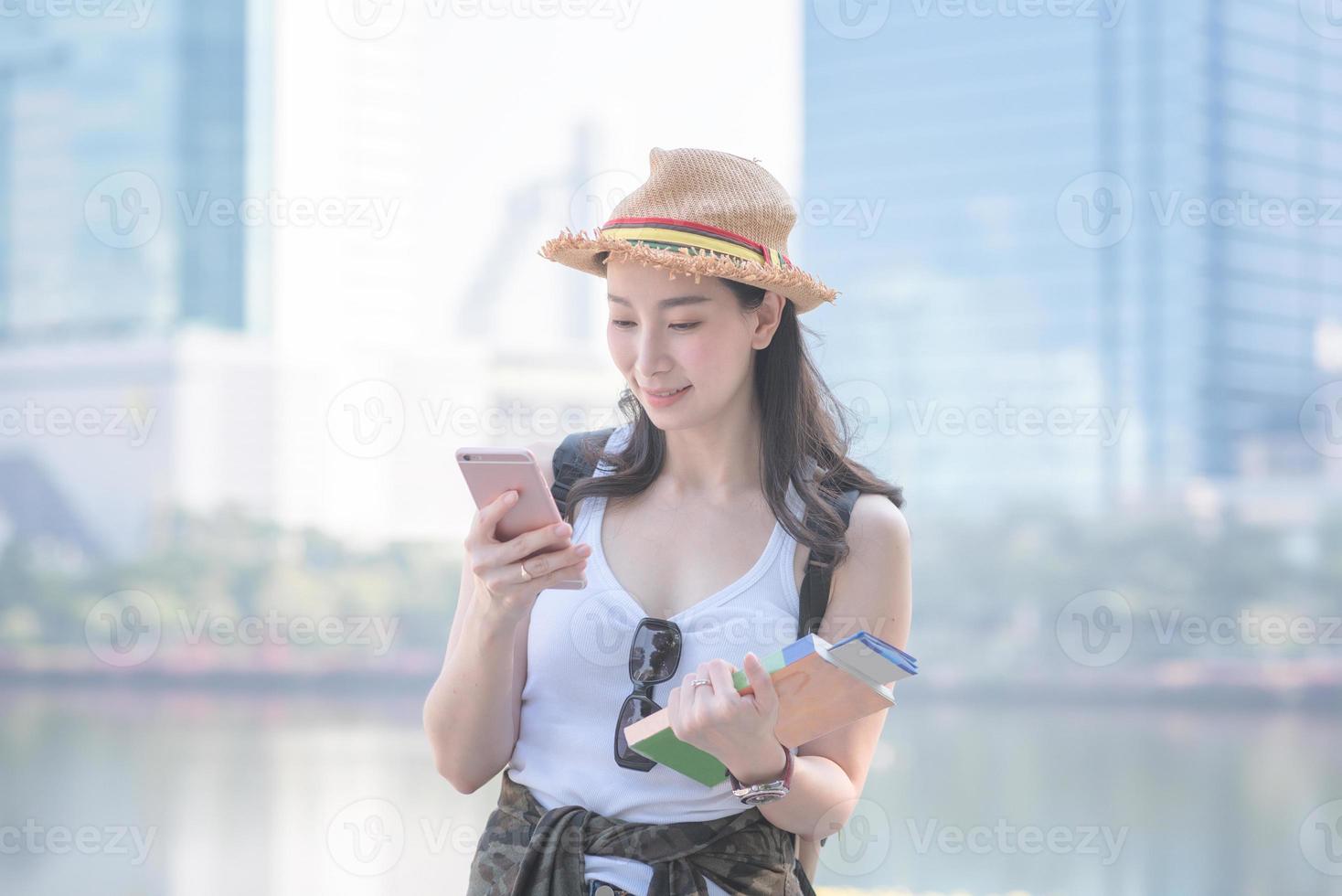 mooie aziatische toeristische vrouw die lacht en op zoek is naar toeristische bezienswaardigheden. vakantie reizen in de zomer. foto