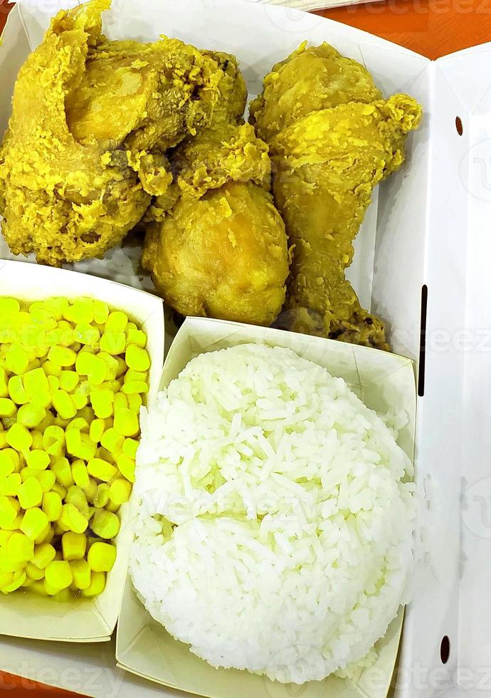 verse heerlijke knapperige gebakken kip goudbruin met witte rijst op witte doos. foto
