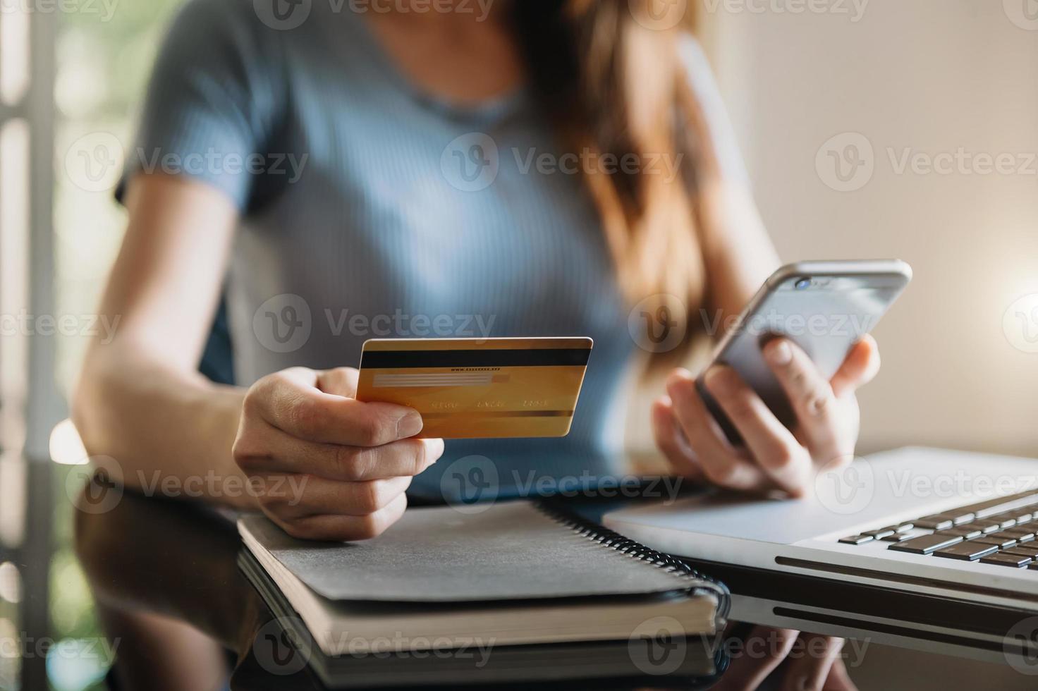 zakenvrouw hand met behulp van slimme telefoon, tablet betalingen en creditcard online winkelen, omni channel, digitale tablet docking toetsenbordcomputer op kantoor in zonlicht foto