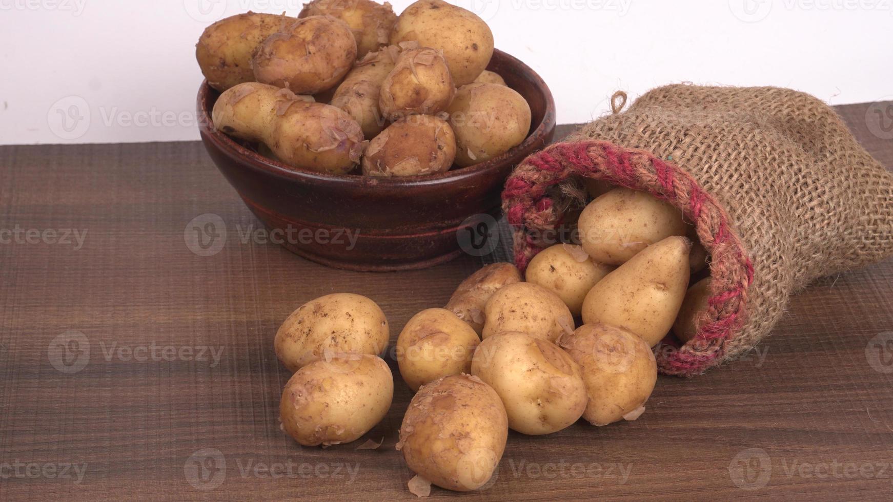 verse kleine aardappelen voor het koken in een houten kom. met kopie ruimte op een witte achtergrond. foto