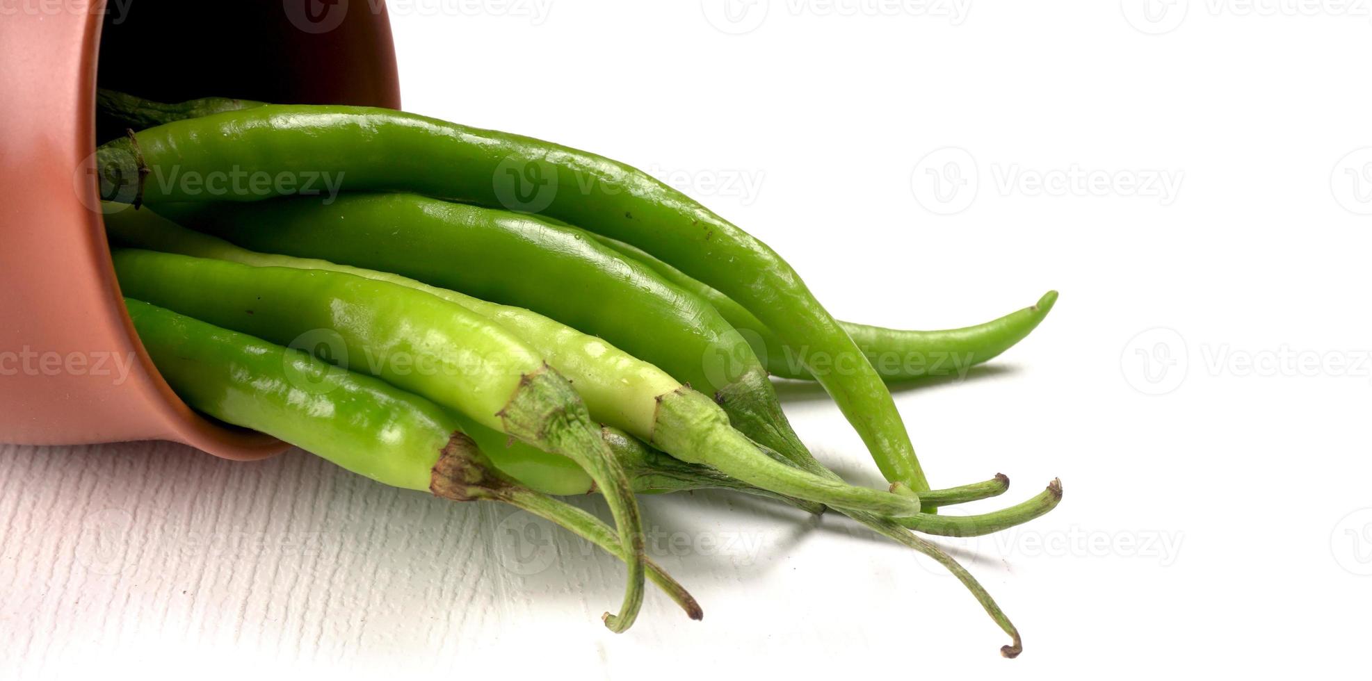 verse lange Indiase groene pepers op houten achtergrond. foto