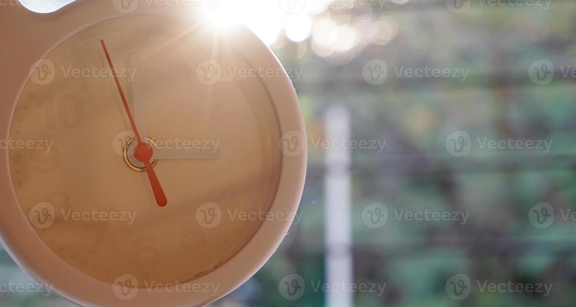 een close-up shot van een witte klok met pijlen die de tijd weergeven. foto