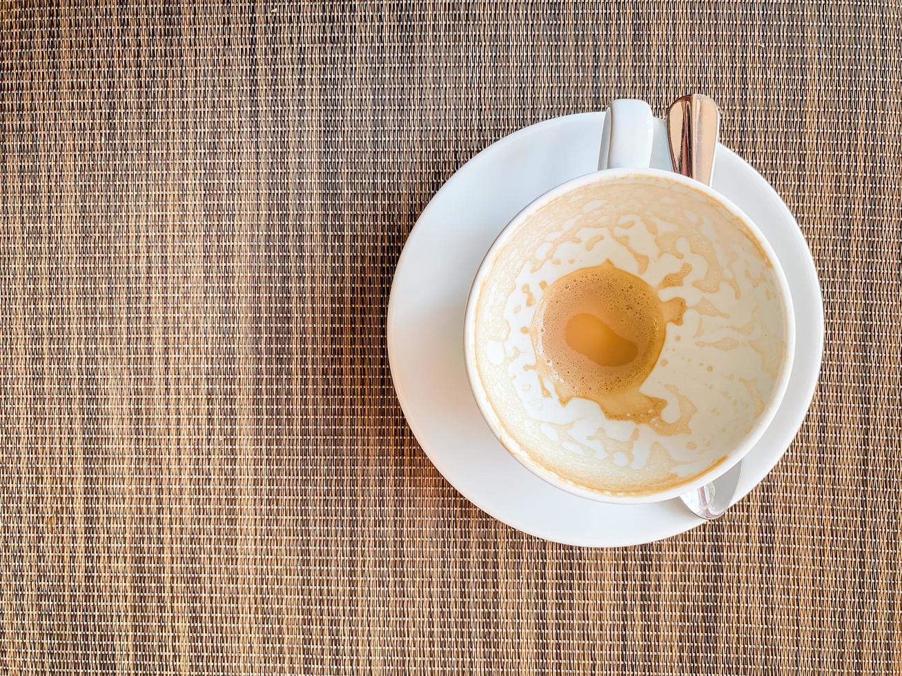 lege koffiekopje op houten bureau op bovenaanzicht. als ontbijt foto