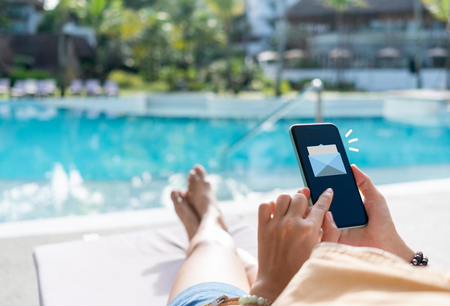 de hand van een vrouw verzendt en ontvangt e-mails op haar smartphone. concept van zakelijke communicatietechnologie. foto