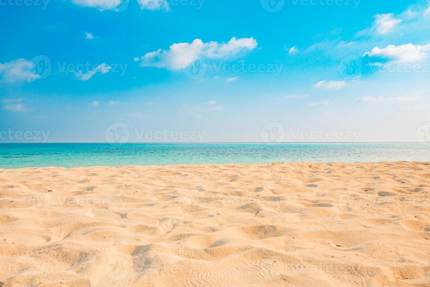 close-up van zand op het strand en de blauwe zomerhemel. panoramisch strandlandschap. leeg tropisch strand en zeegezicht. oranje en gouden zonsonderganghemel, zacht zand, kalmte, rustig ontspannend zonlicht, zomerstemming foto