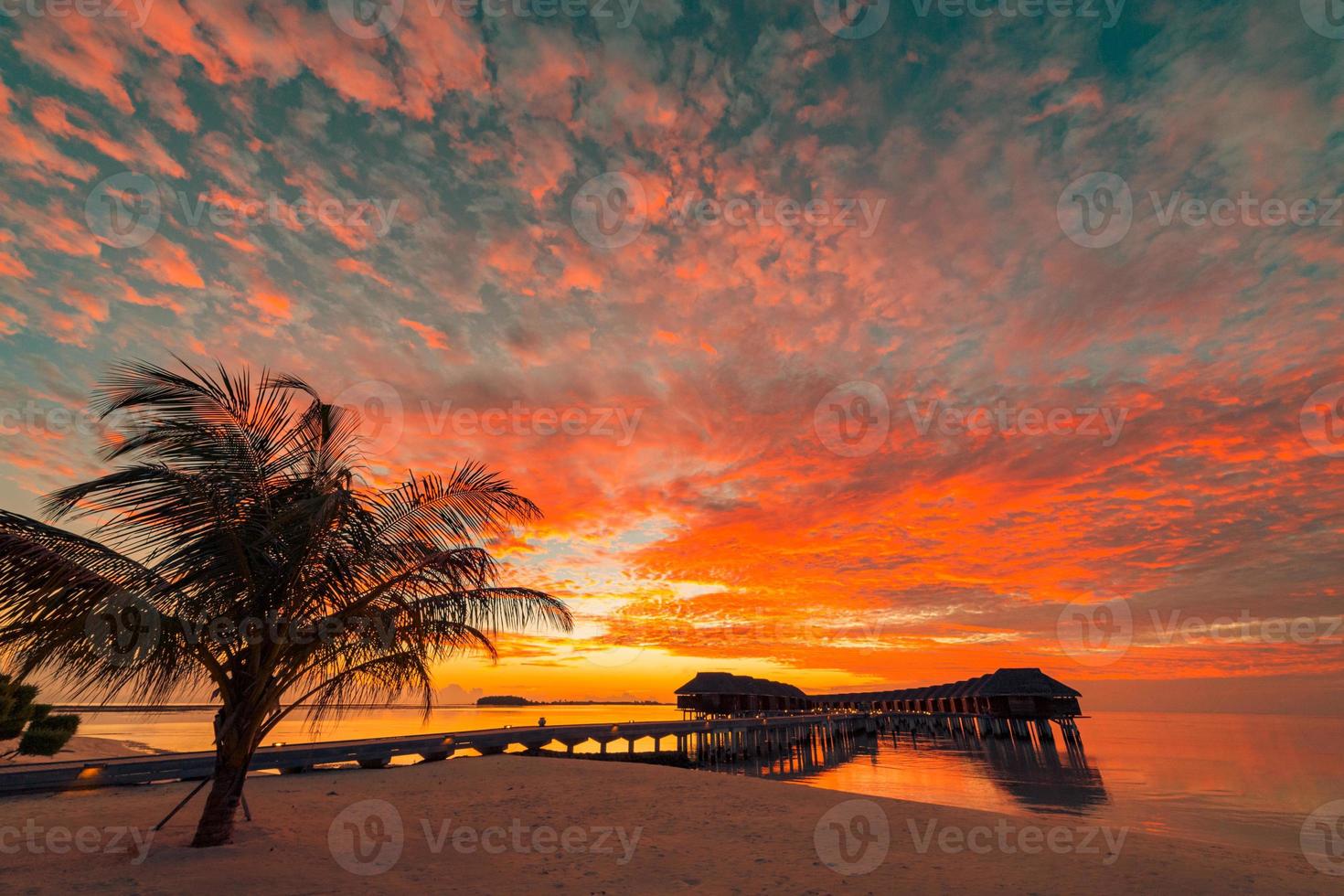 prachtige zonsondergang strandscène. kleurrijk uitzicht op de lucht en de wolken met kalme zee en ontspannende tropische sfeer foto