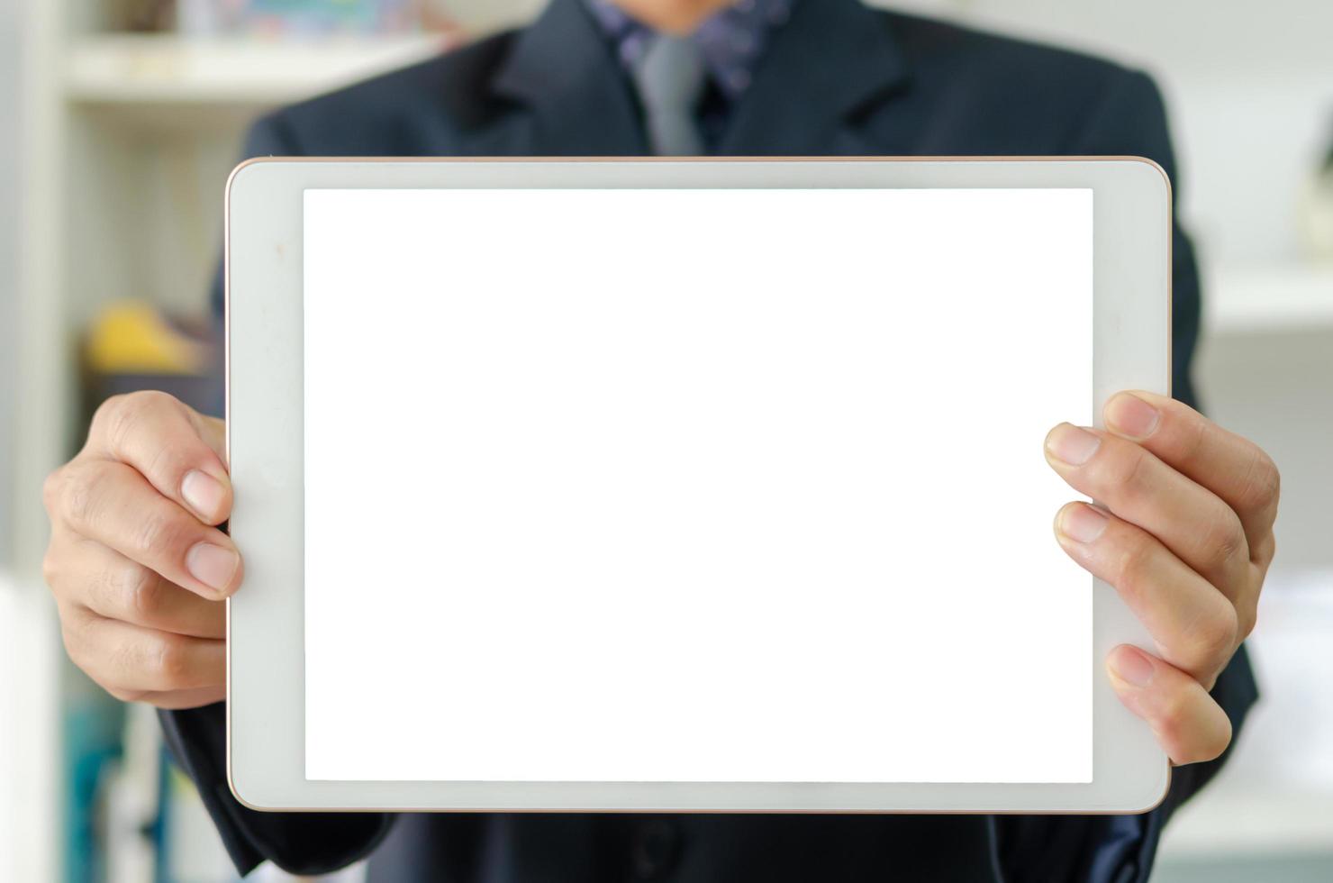 zakenman die een lege witte tablet met touchscreen houdt. gebruikt om tekst of informatie te plaatsen om nieuws te adverteren of producten online te verkopen. concept marketing bedrijf foto