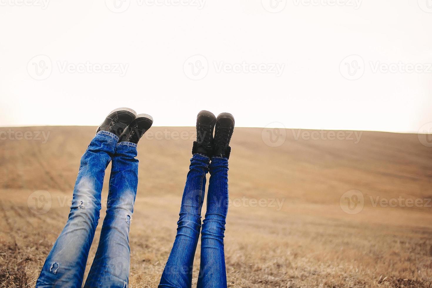 een vrouwen- en mannenvoeten hoog in de lucht. schieten in het veld op herfsttijd. plaats voor inscriptie foto