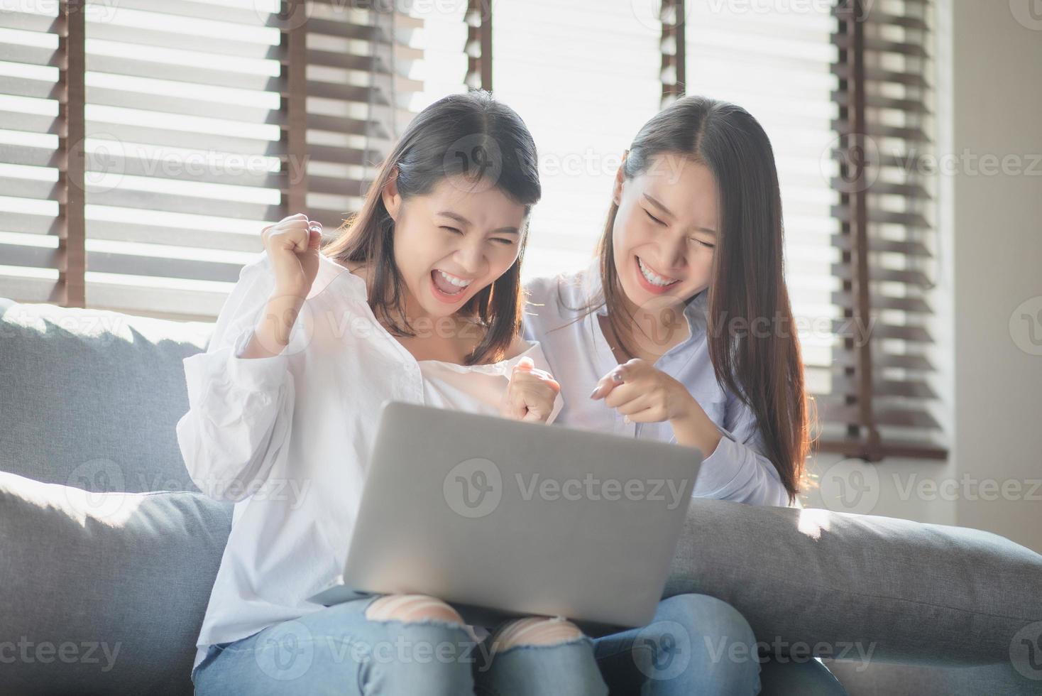 Inconsistent Modderig ik lees een boek twee jonge vrouwen gebruiken een laptop om online te winkelen via internet  terwijl ze thuis veilig blijven 4886834 Stockfoto