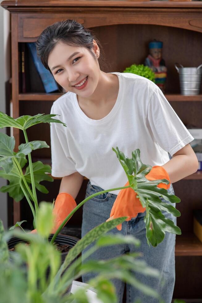 de vrouw droeg oranje handschoenen en plantte bomen in het huis. foto