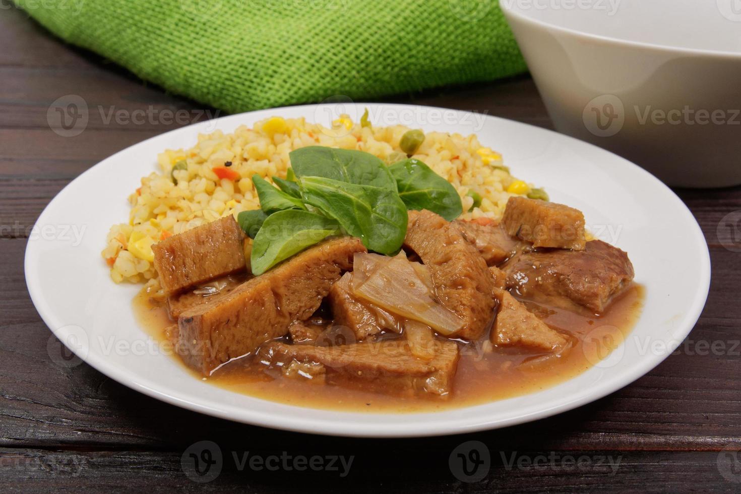 tempeh met tomatensaus en gierst op tafel foto