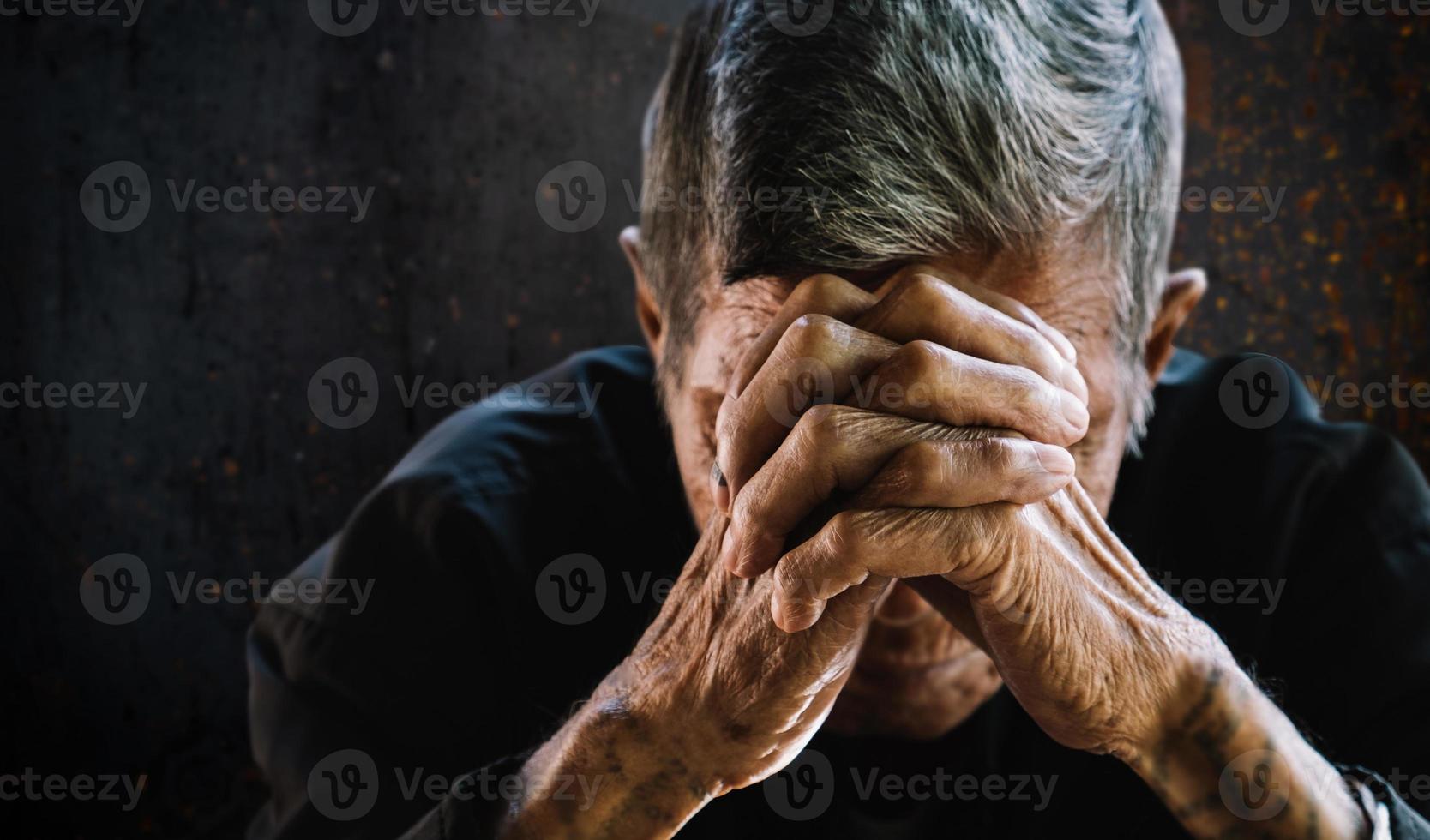 senior man bedekt zijn gezicht met zijn hands.vintage toon foto