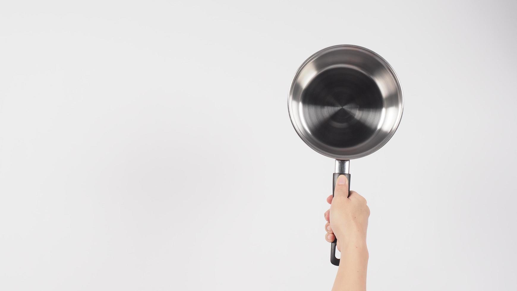 potten schoonmaken. man hand op witte achtergrond die de non-stick pot schoonmaakt foto