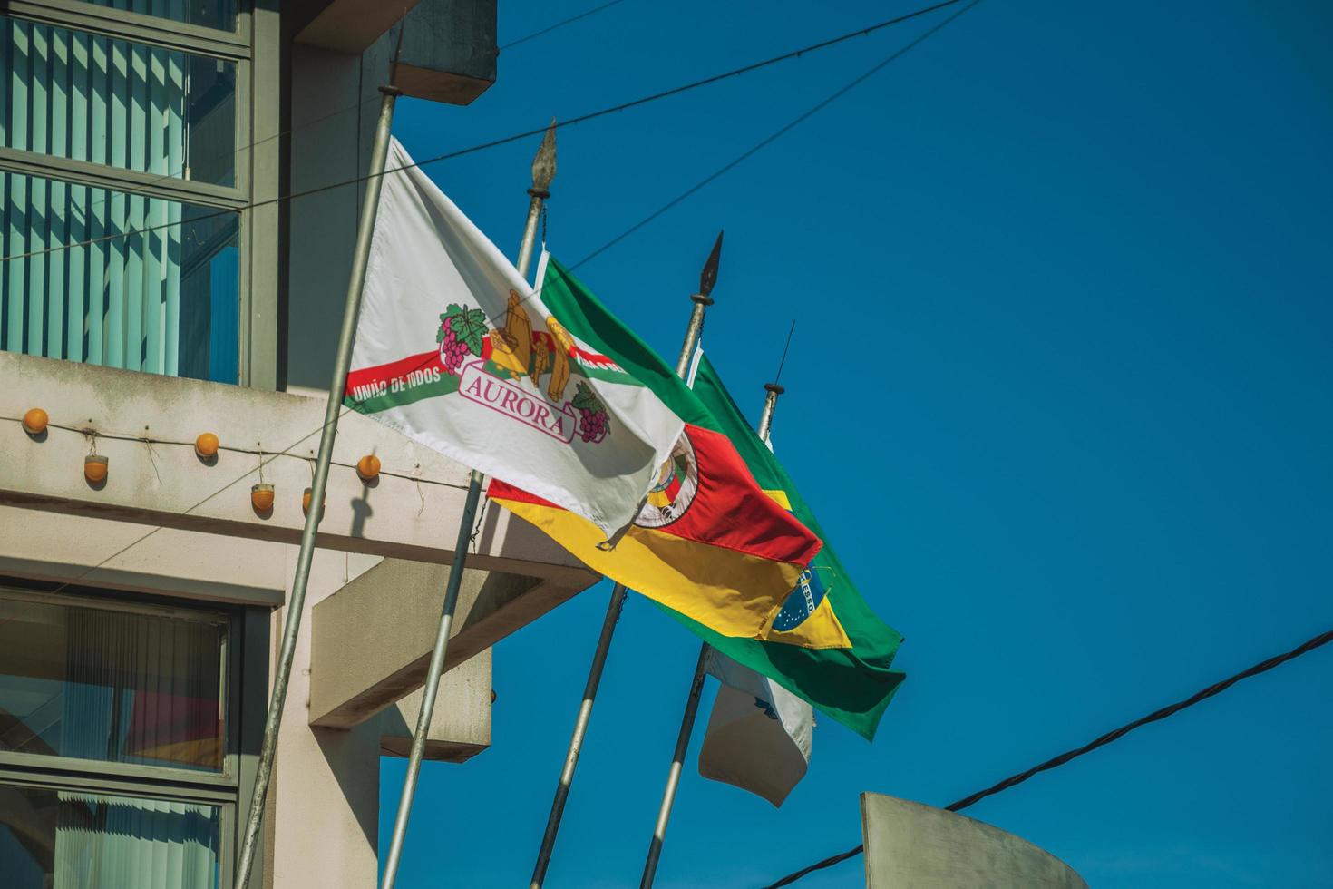 bento goncalves, brazilië - 11 juli 2019. vlaggen van het aurora-wijnmakerijbedrijf, rio grande do sul, brazilië en de stad bento goncalves. een vriendelijk plattelandsstadje dat bekend staat om zijn wijnproductie. foto