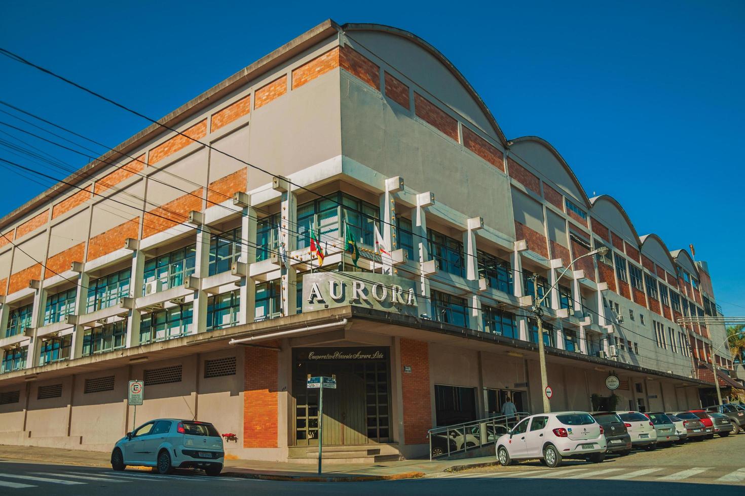 bento goncalves, brazilië - 11 juli 2019. gevel van aurora wijnmakerij gebouw met het uithangbord van het bedrijf in een straat van bento goncalves. een vriendelijk plattelandsstadje dat bekend staat om zijn wijnproductie. foto