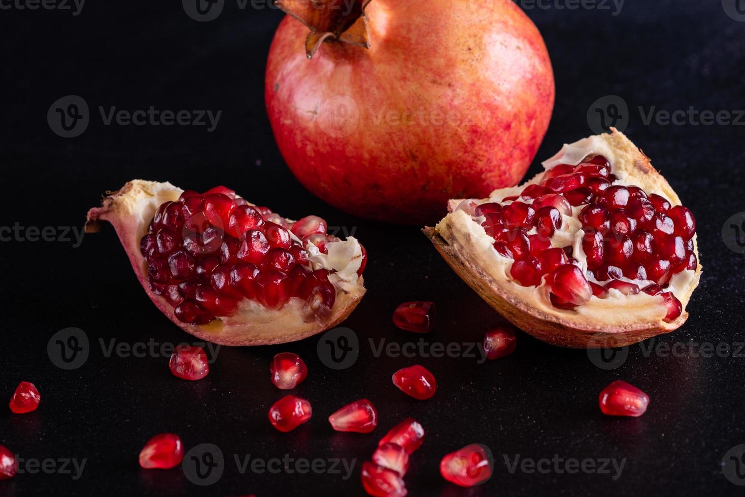 smakelijke verse rode granaatappel op een donkere betonnen ondergrond foto