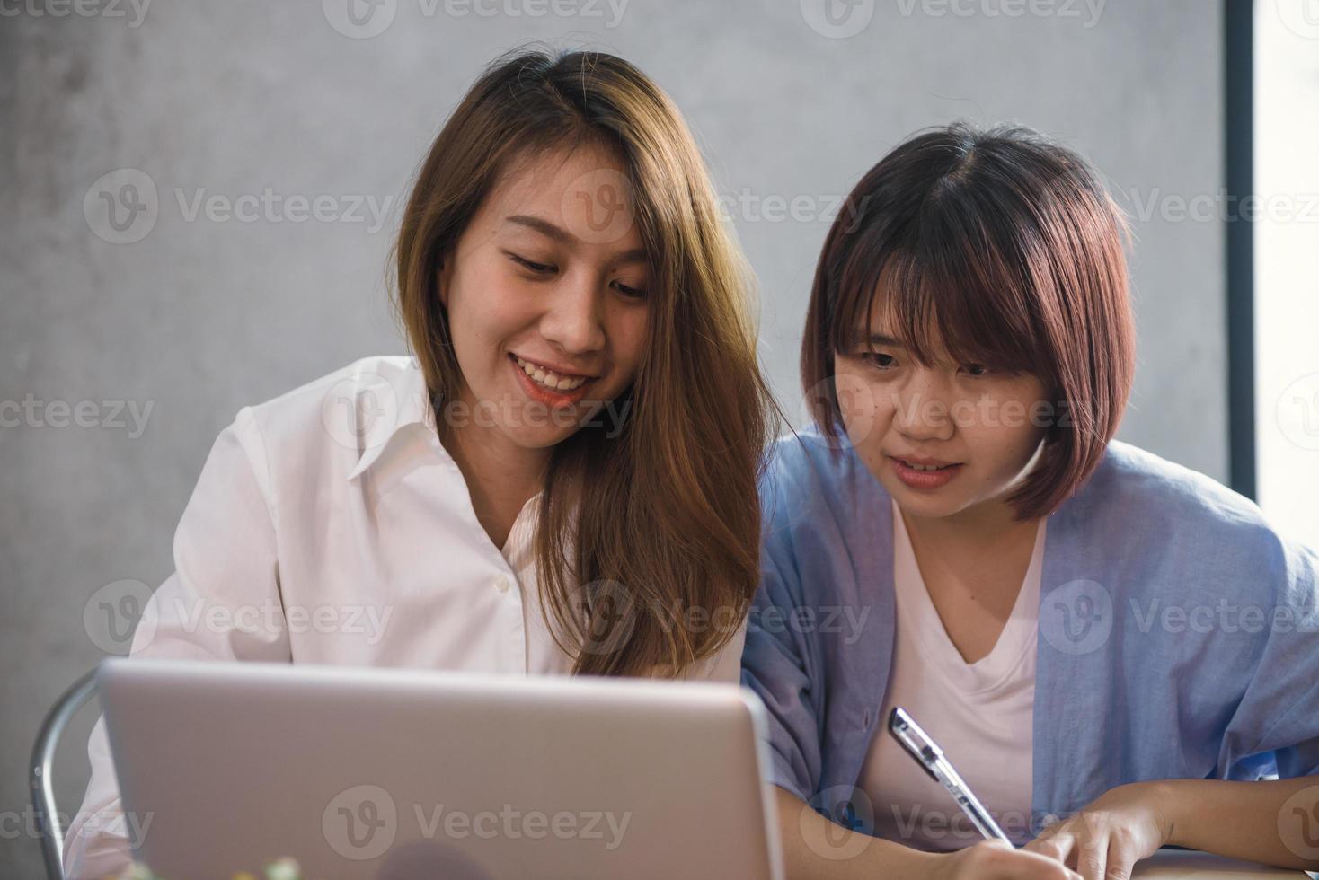 twee jonge zakelijke vrouwen zitten aan tafel in café. Aziatische vrouwen met behulp van laptop en kopje koffie. freelancer werken in coffeeshop. werken buiten kantoor levensstijl. een-op-een ontmoeting. foto