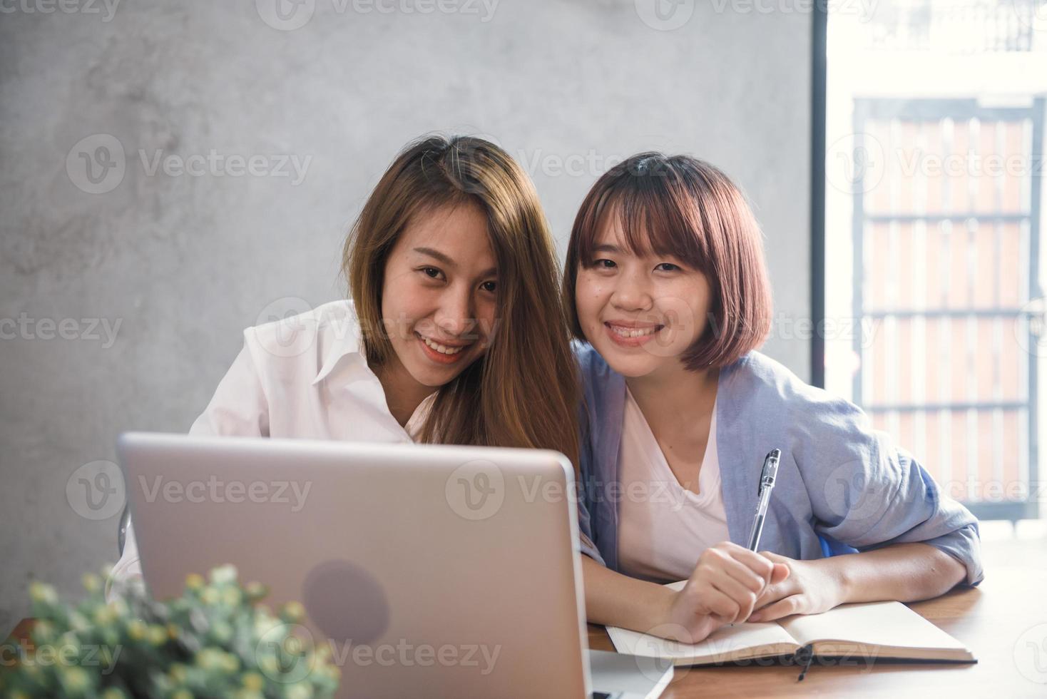 twee jonge zakelijke vrouwen zitten aan tafel in café. Aziatische vrouwen met behulp van laptop en kopje koffie. freelancer werken in coffeeshop. werken buiten kantoor levensstijl. een-op-een ontmoeting. foto