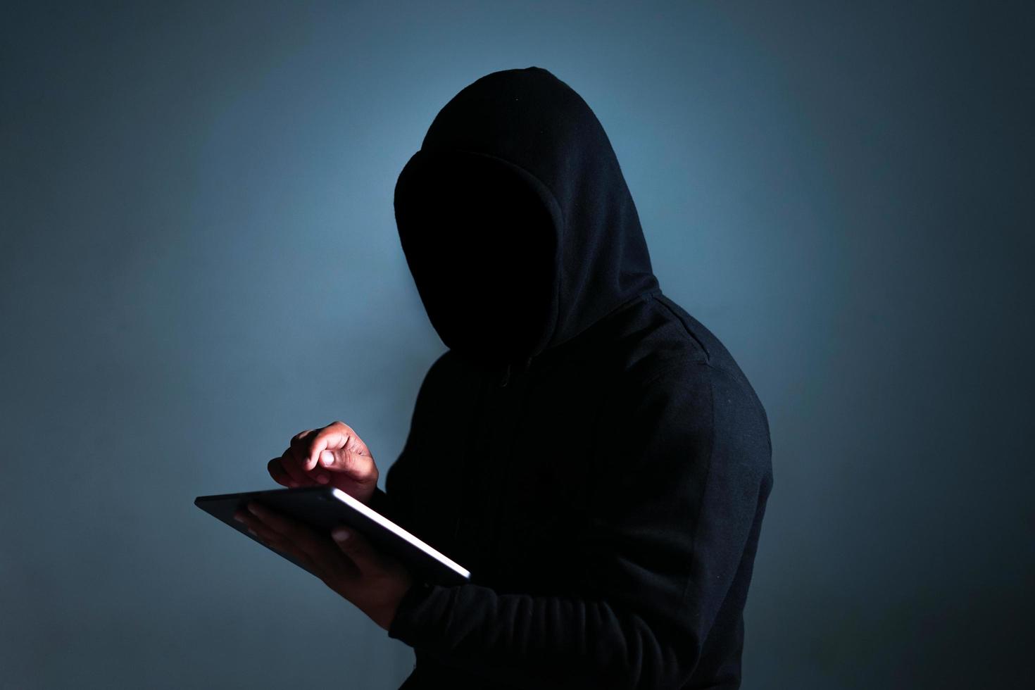Indonesië, 21122021 - een man in zwarte hoodie met een tablet foto