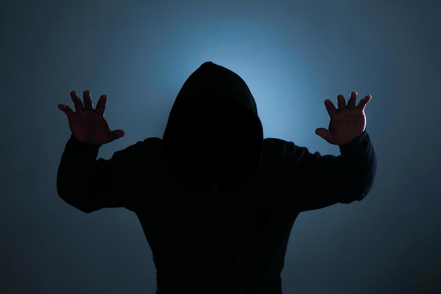Indonesië, 21122021 - een silhouet van een man in een zwarte hoodie foto