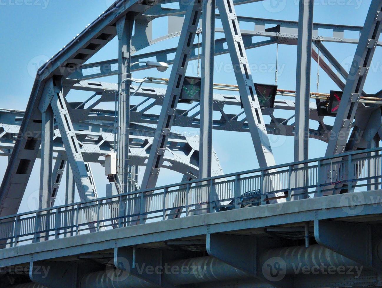 ijzeren bruggen over de rivier en verkeerslichten rood groene pijlen op de vloer frisse blauwe lucht foto