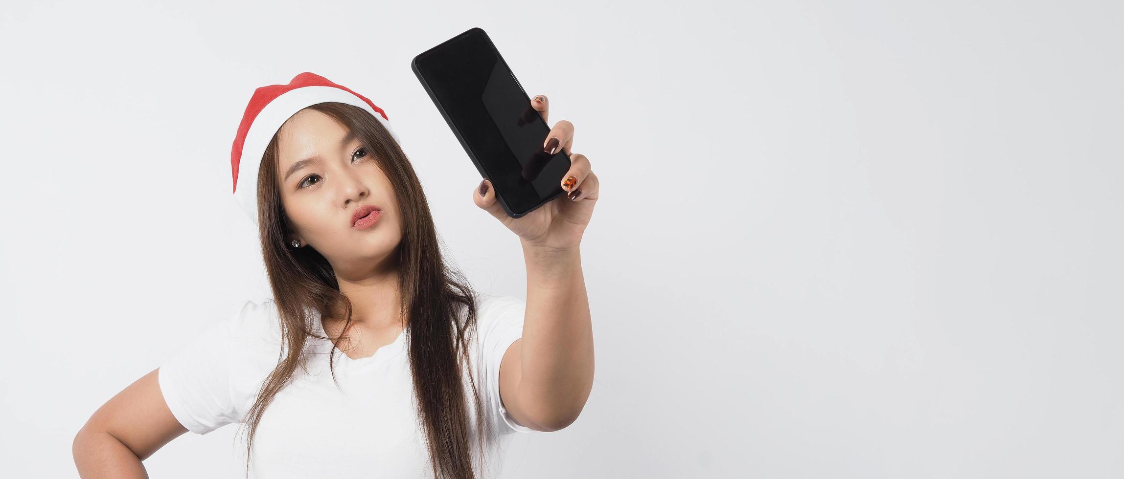 Aziatische vrouw met smartphone in de hand die zich voordeed als selfie of videogesprek foto