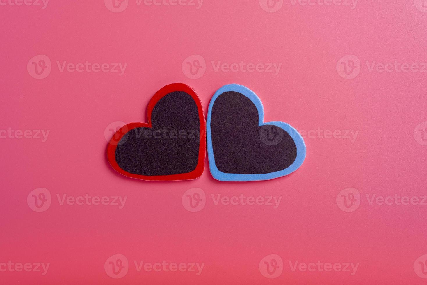 valentijnsdag, moederdag, verjaardag. twee decoratieve hartjes in het midden op een roze achtergrond foto