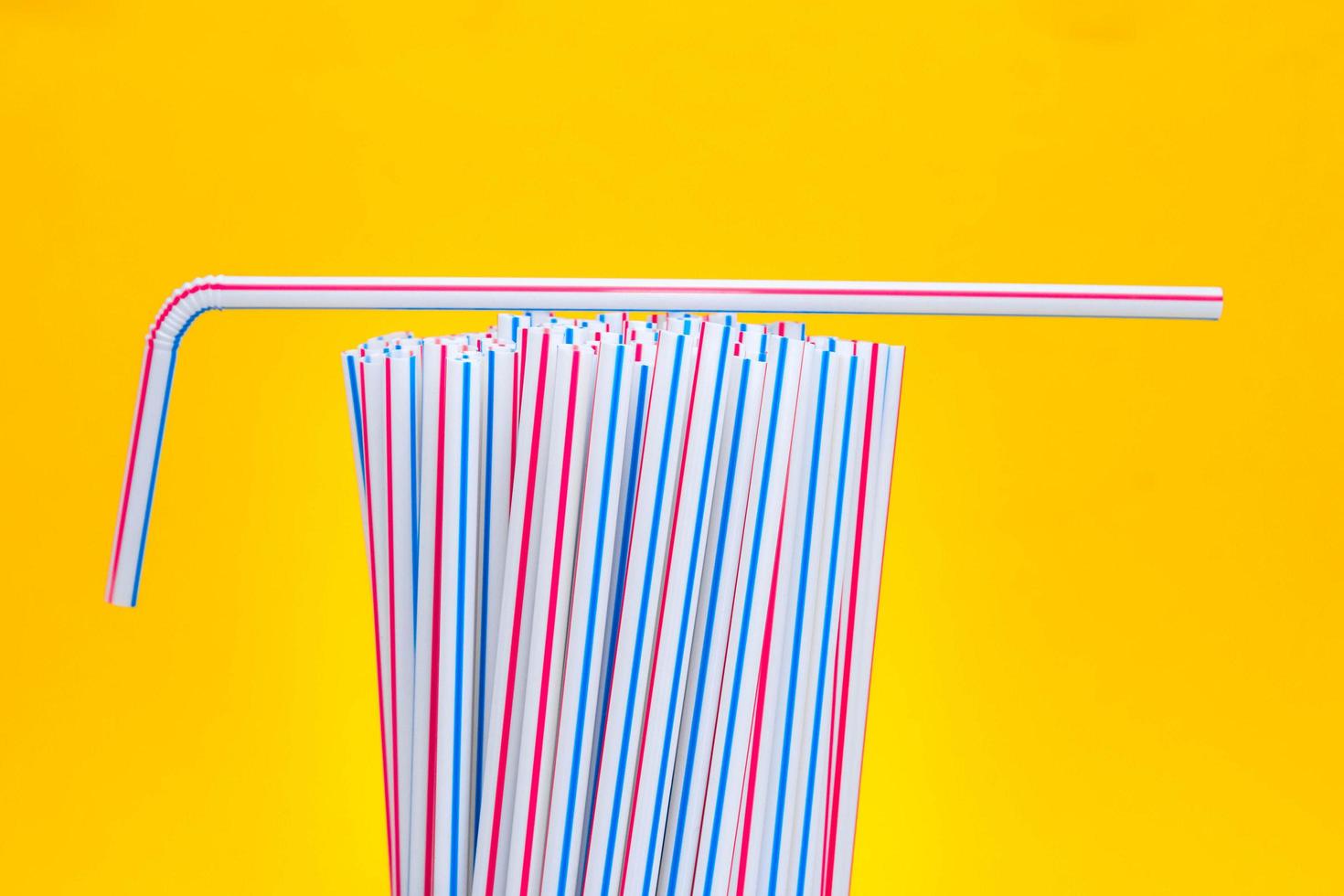 plastic rietjes drinken op een gele achtergrond foto