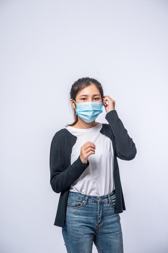 een zieke vrouw met hoofdpijn droeg een masker en legde een hand op haar hoofd. foto