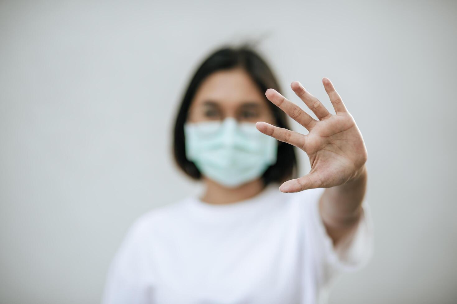 vrouwen dragen maskers en verbieden door hun handen vooraan op te steken. foto