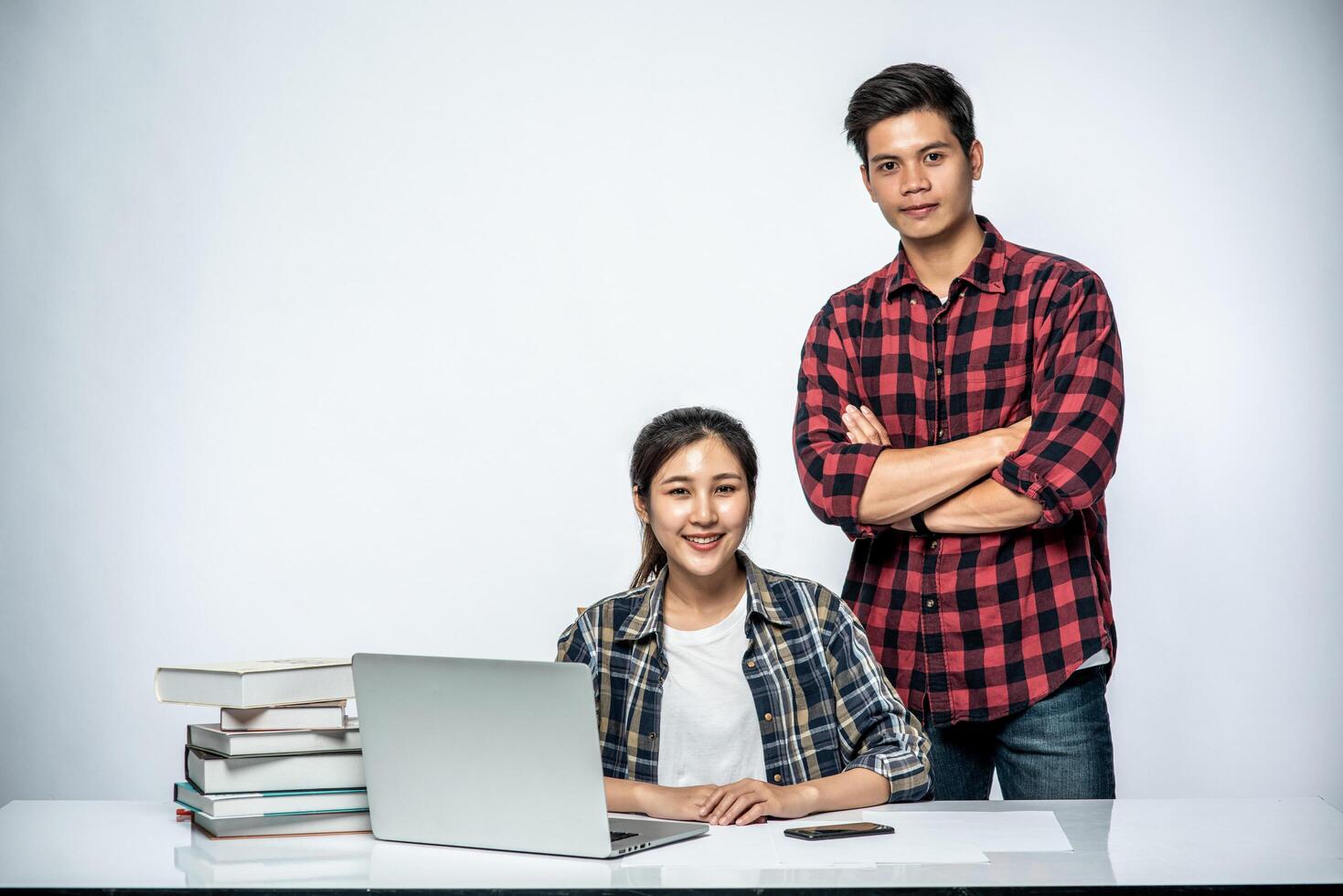 mannen leren vrouwen werken met laptops op het werk. foto