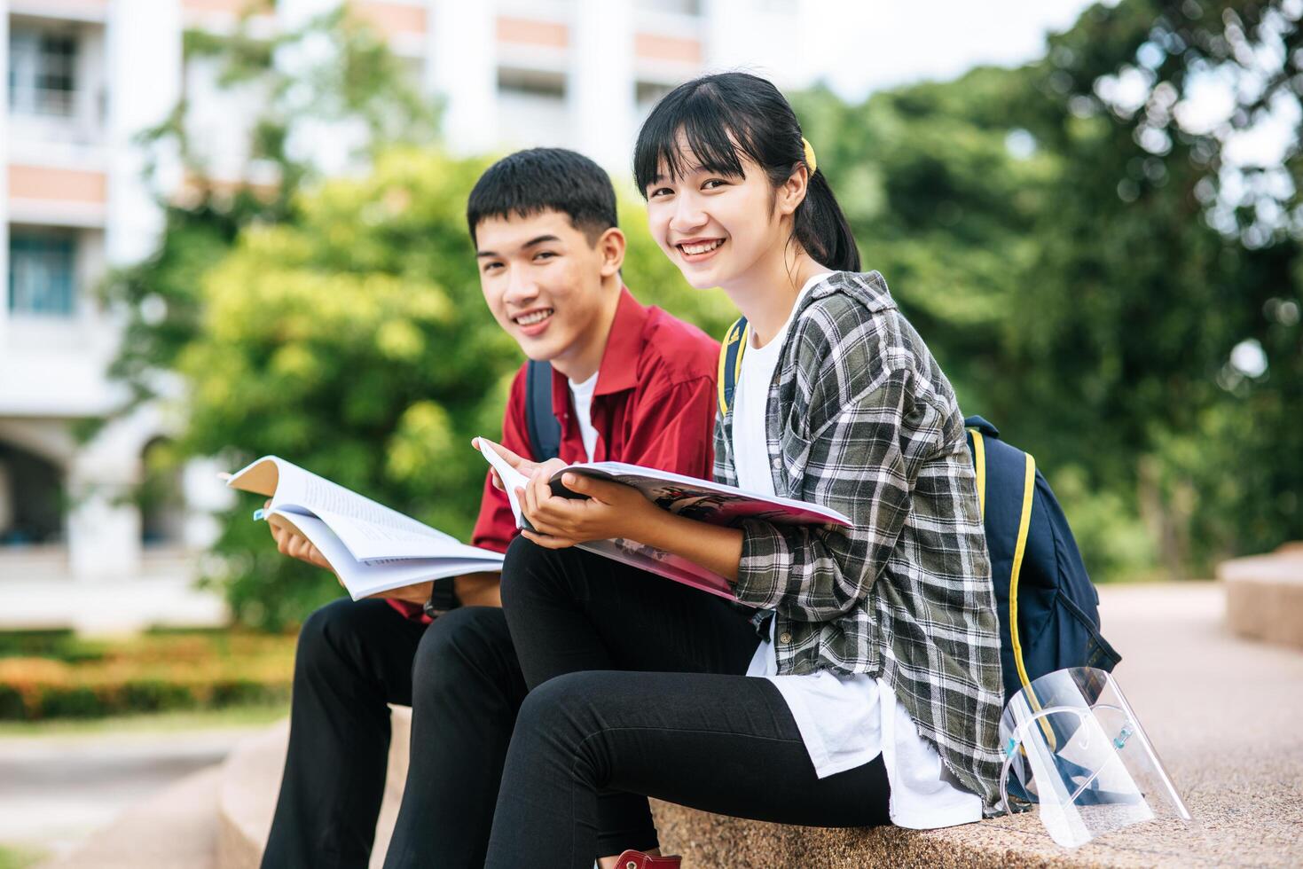 mannelijke en vrouwelijke studenten zitten en lezen boeken op de trap. foto