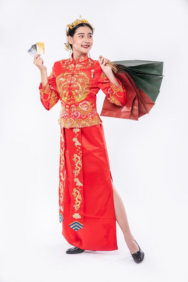 vrouw draagt cheongsam-pak en haalt veel dingen uit het gebruik van creditcard in Chinees nieuwjaar foto