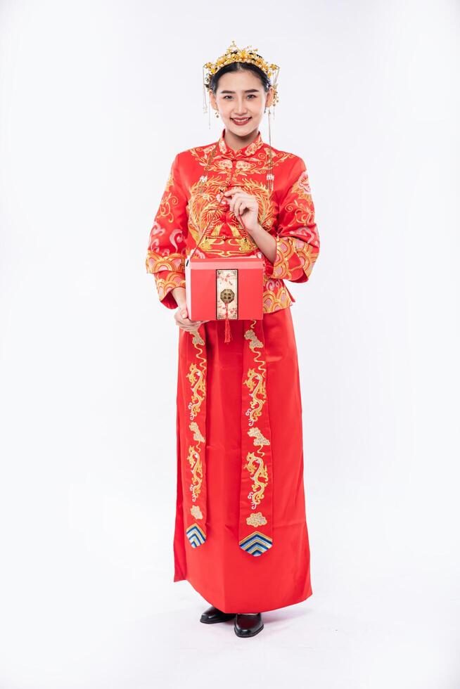 vrouw draagt cheongsam-pak glimlach om de grote prijs van het spel van het bedrijf in Chinees nieuwjaar te laten zien foto