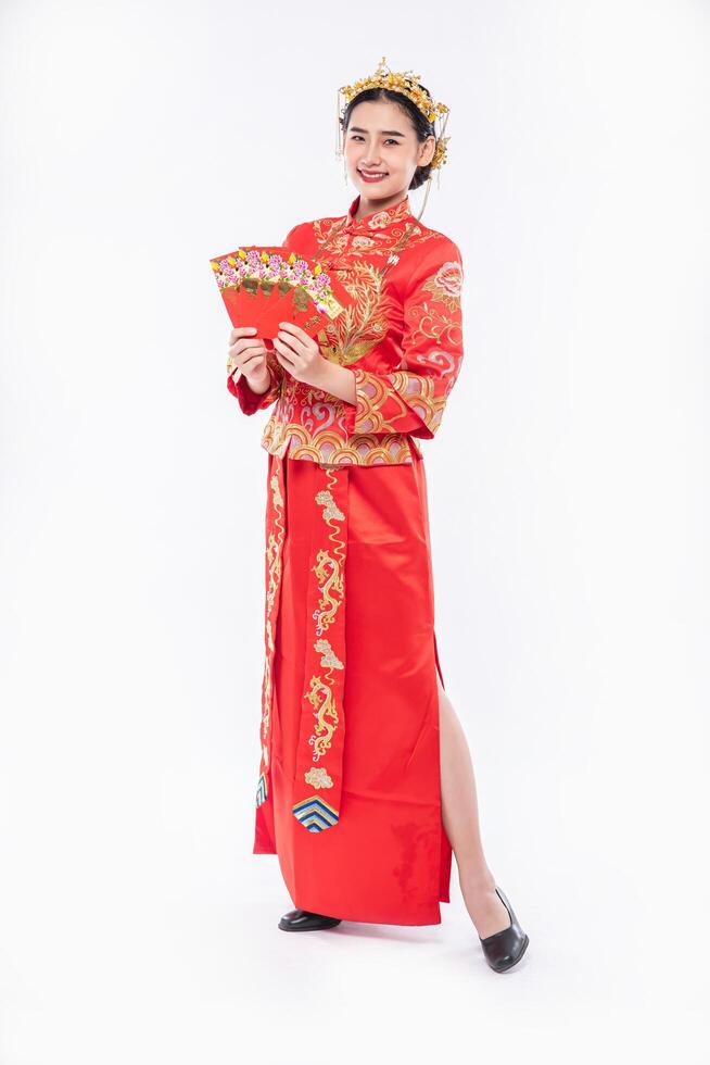 vrouw draagt cheongsam-pak en zwarte schoen blij dat ze cadeaugeld krijgt van de baas in Chinees nieuwjaar foto