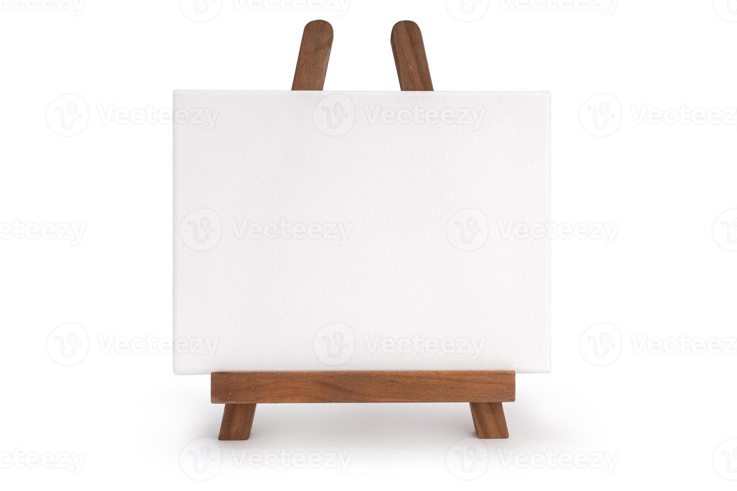 houten schildersezel met leeg canvas dat op witte achtergrond wordt geïsoleerd foto