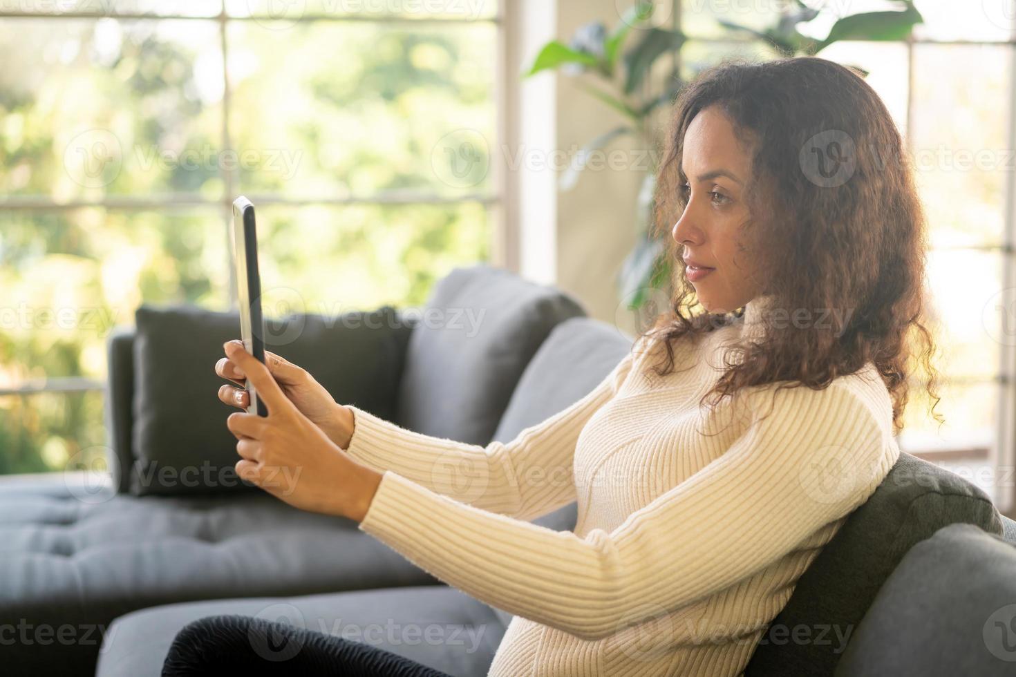 latijnse vrouw videoconferentie op tablet met blij gevoel foto