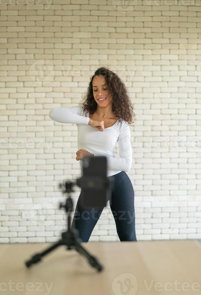 latijnse vrouw heeft haar dansvideo gemaakt met een smartphonecamera. om video te delen met een toepassing voor sociale media. foto