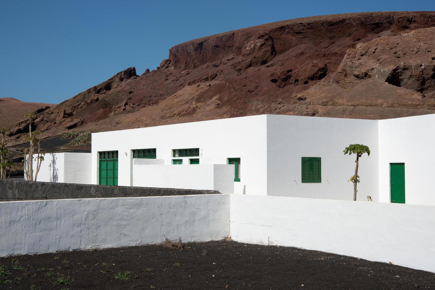 Lanzarote, Spanje, 2013, traditioneel wit huis op Lanzarote. vulkanisch land, groene deur en ramen. canarische eilanden, spanje. foto