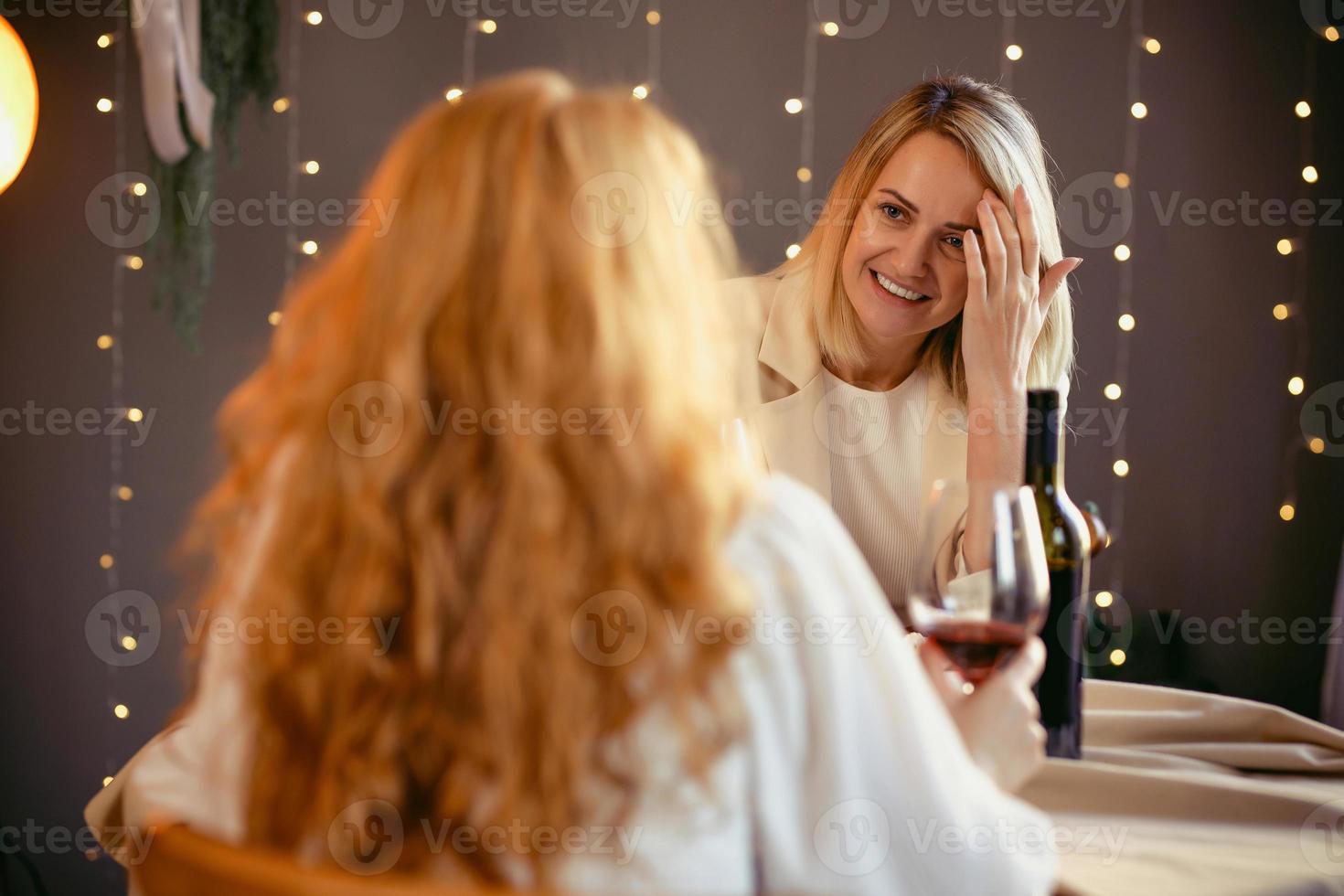 lesbisch koppel aan het eten in een restaurant. meisje geeft een cadeau aan haar geliefde foto