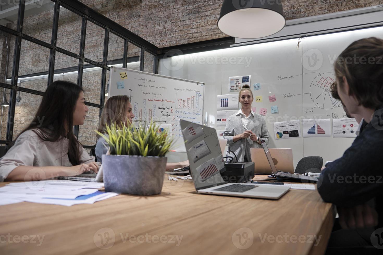 vergadering van een professioneel team, multiraciale collega's en collega's gebrainstormd en presentatie in de vergaderruimte van het kantoor met een cuacasian vrouwelijke baas, over financiën en marketing. foto